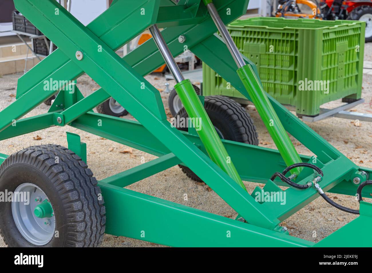 Two Pistons Hydraulic Platform at Green Agriculture Trailer Stock Photo