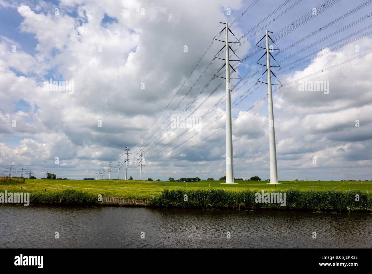 Expansion of the high-voltage grid with many high-voltage pylons to meet the growing demand for electricity, photo taken in the province of Groningen, Stock Photo
