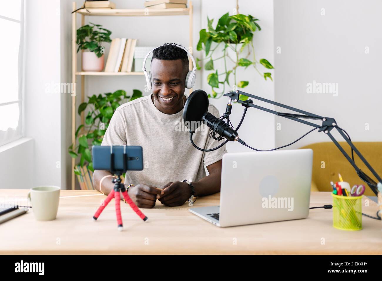 Young adult african man streaming live video at home studio Stock Photo