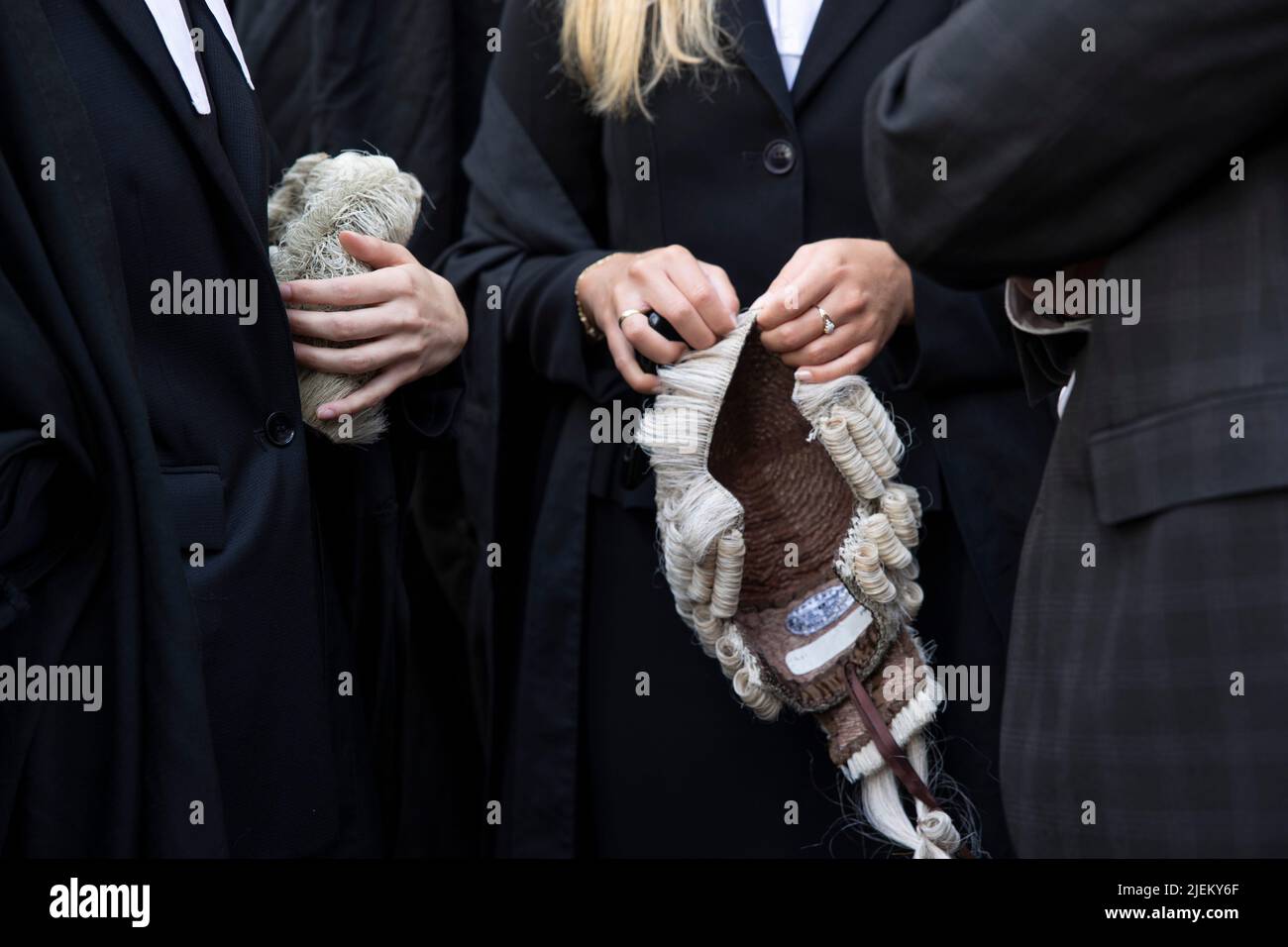Criminal barristers are seen holding their wigs during the strike outside Old Bailey. Criminal barristers walkout from courts in strike around the UK over dispute in pay. The Criminal Bar Association (CBA) said incomes for junior criminal barristers have fallen 30% over the last 20 years and standing at average income after expenses of £12200 in the first 3 years of practice. They demand a 25% uplift in legal aid fee, which is more than the 15% minimum recommended by the Criminal Legal Aid Review published in last December. Stock Photo