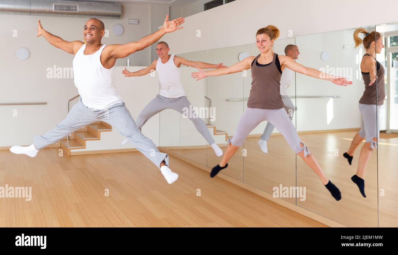 Positive young adults jumping during dance training Stock Photo