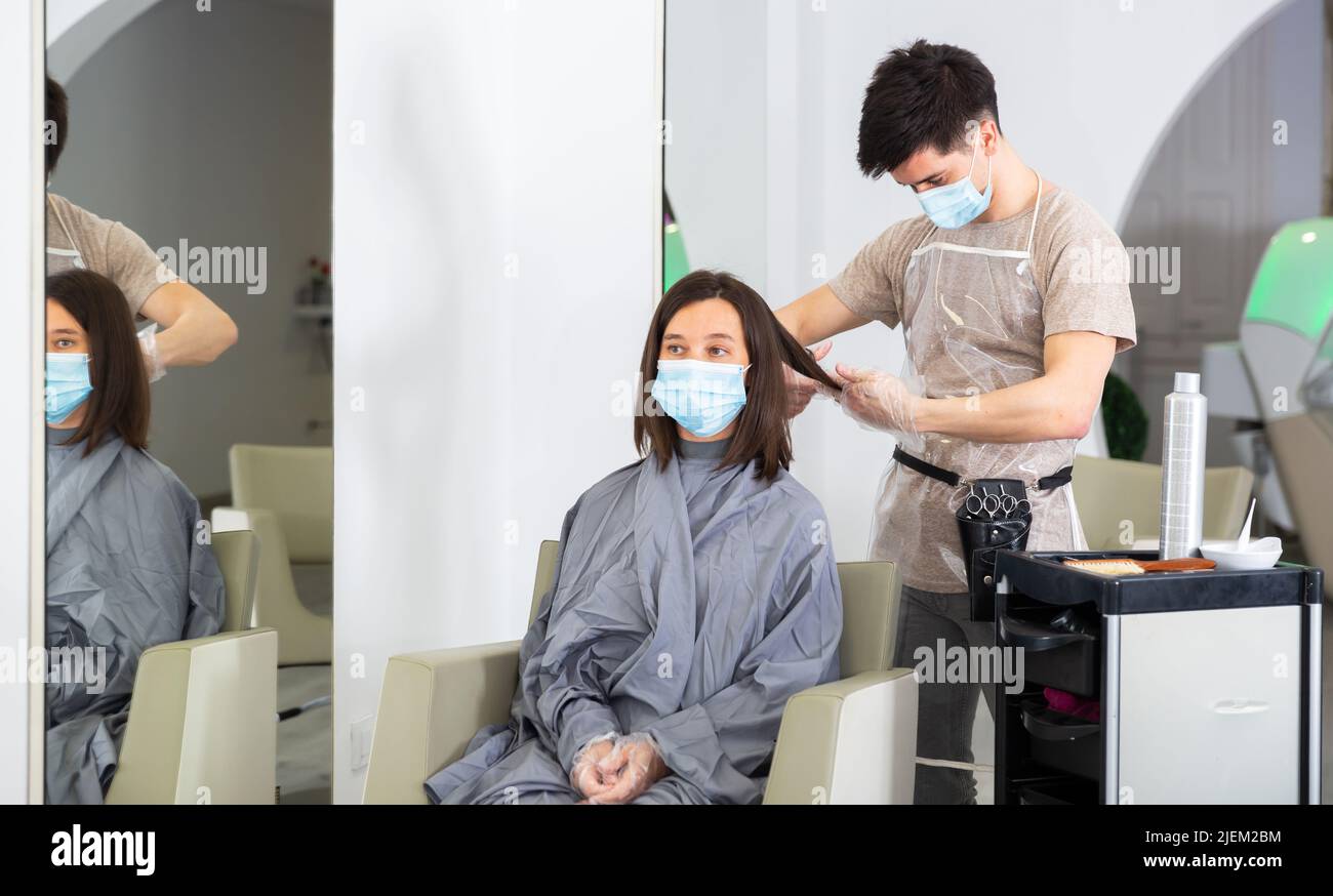 Man doing haircut for woman in salon using face masks Stock Photo Alamy