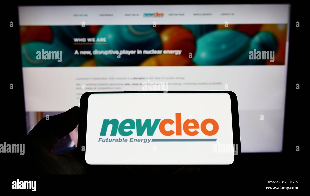 Person holding smartphone with logo of British energy company newcleo S.r.l. on screen in front of website. Focus on phone display. Stock Photo