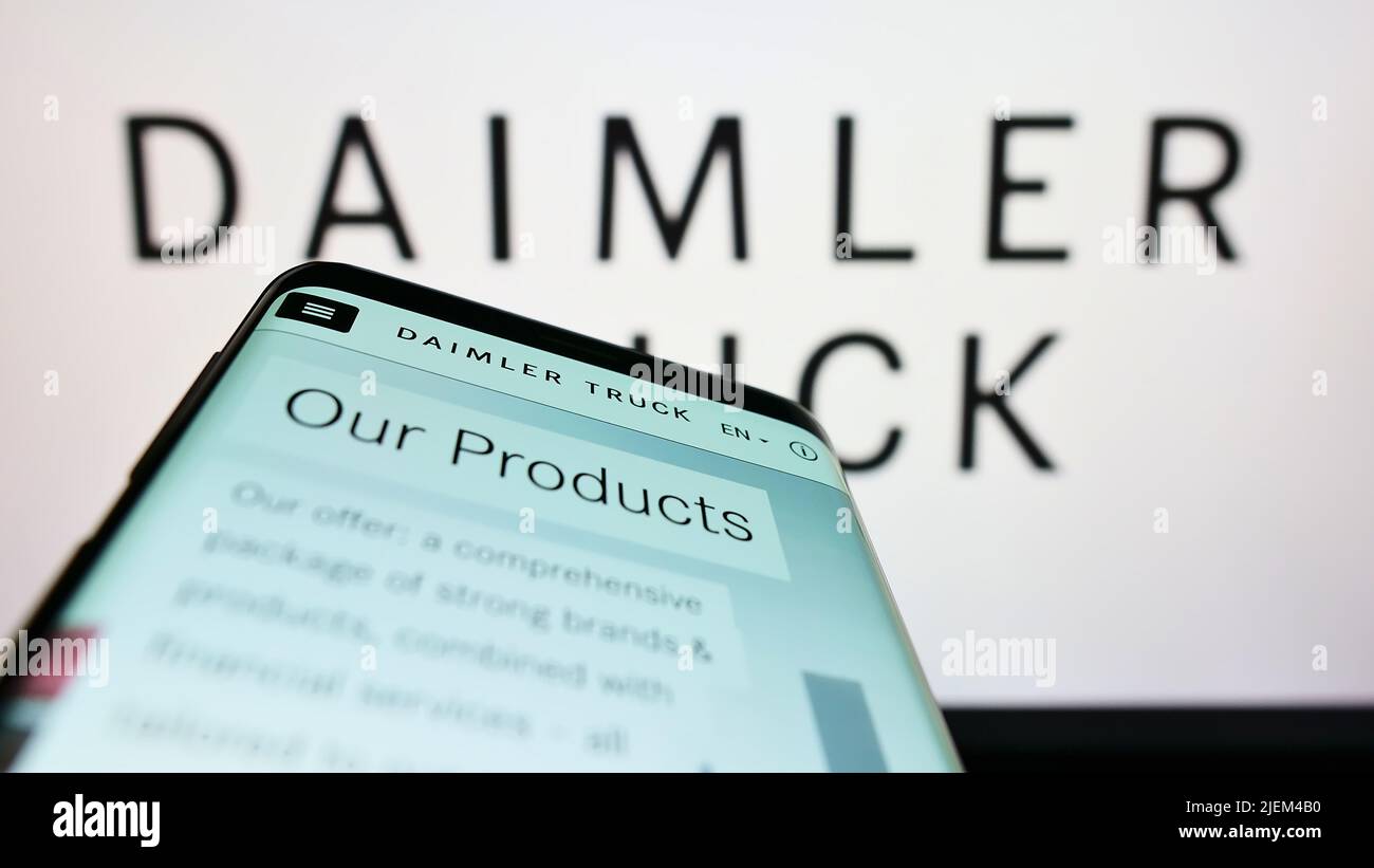 Mobile phone with website of automotive company Daimler Truck Holding AG on screen in front of business logo. Focus on top-left of phone display. Stock Photo