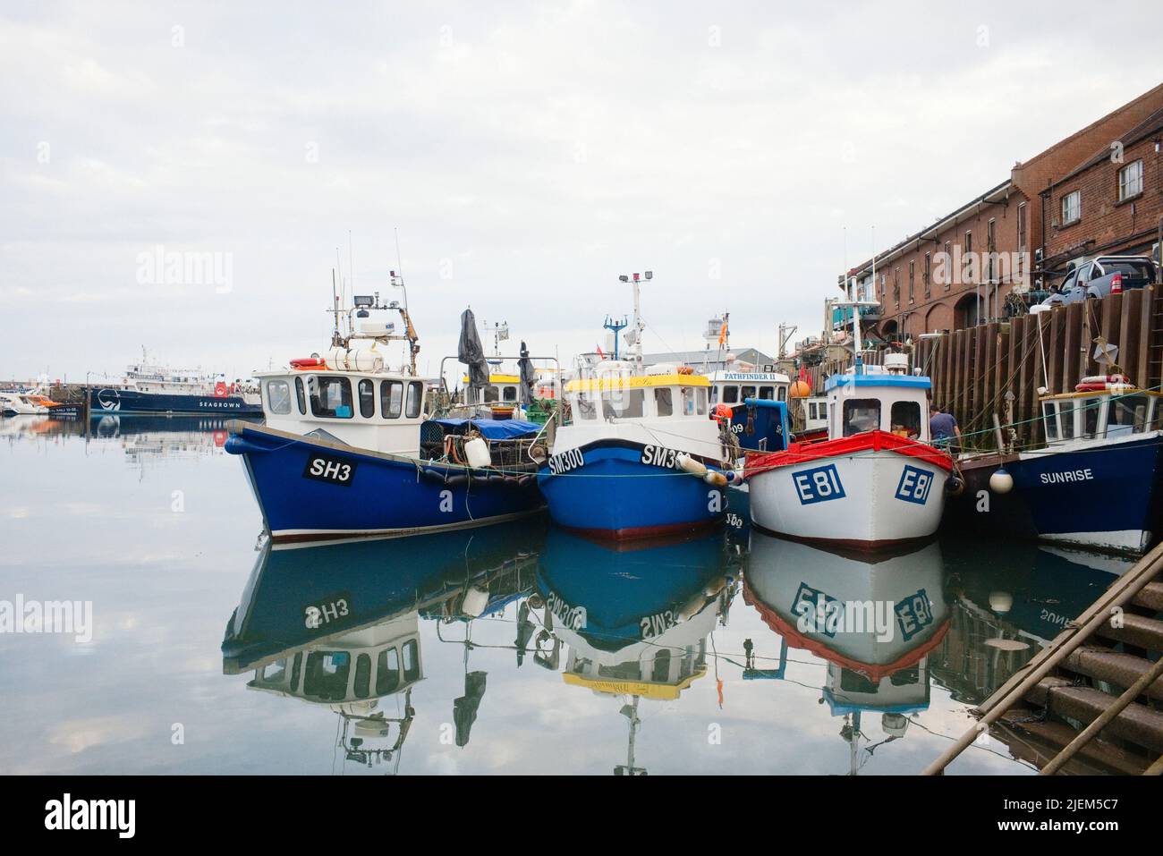 Small inshore fishing boats moored alongside the quay in Scarborough harbour Stock Photo