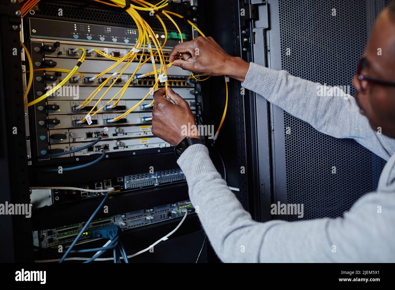 Close up of IT engineer connecting cables in server room while setting up data network, copy space Stock Photo