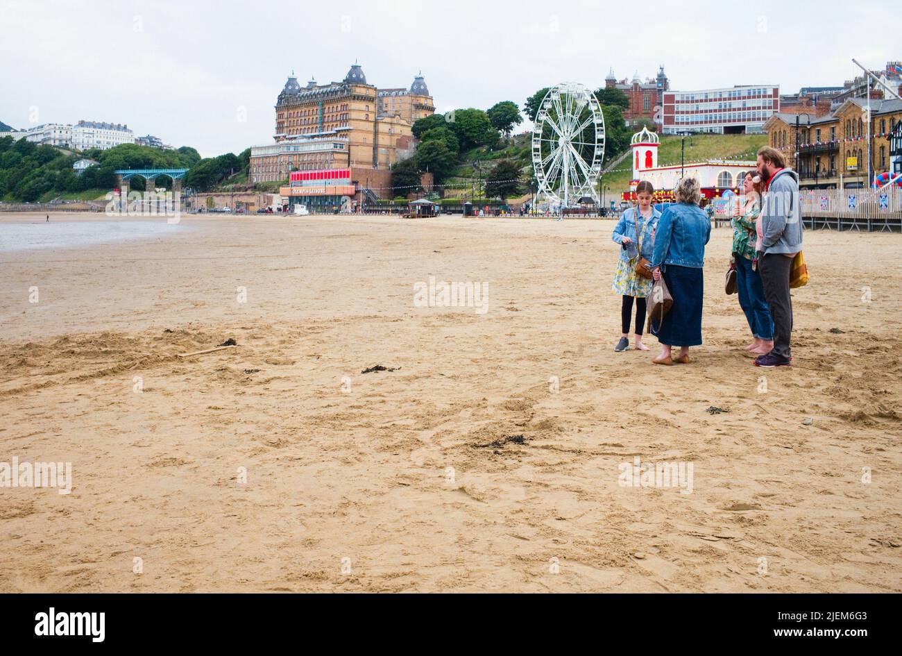Family eating ice creams on the beach at Scarborough during a weekday evening when it is relatively quiet Stock Photo
