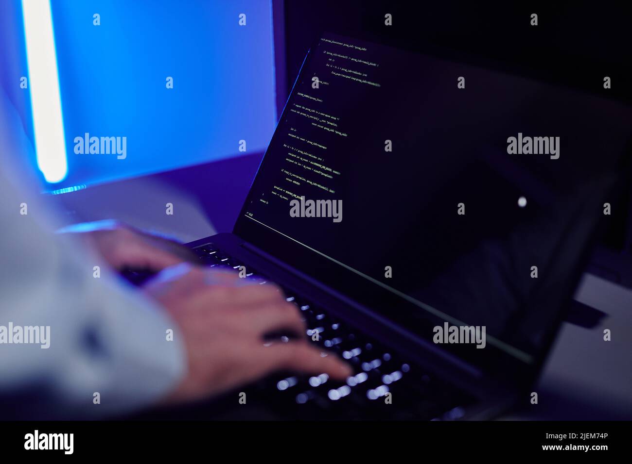 Close up of IT engineer writing code at laptop and setting up server ...