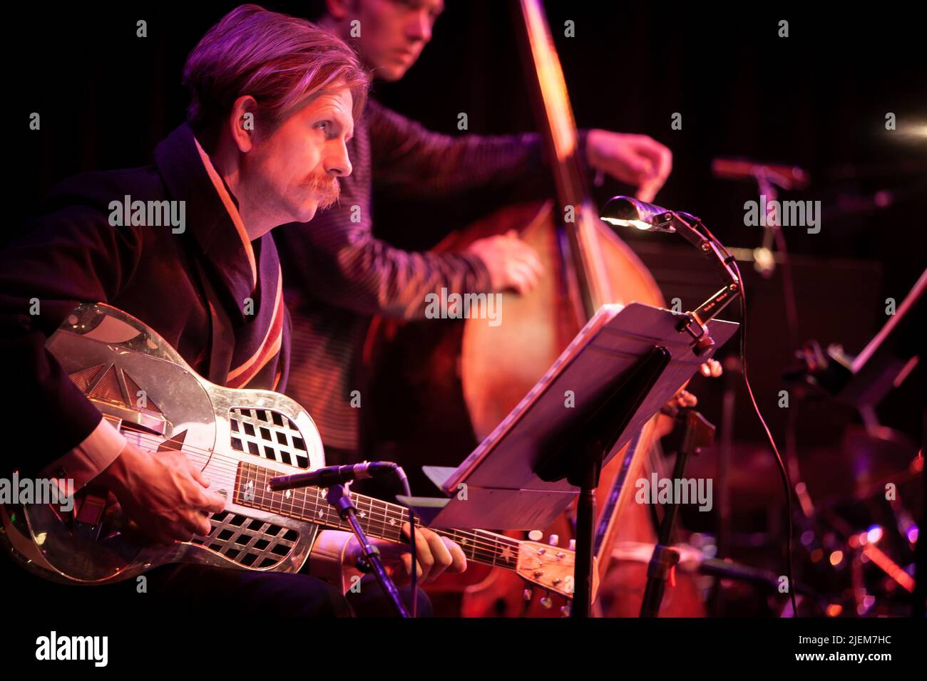 Big Band: guitar and double bass. A jazz guitarist watching the conductor. From a series of images of musicians in a swing Jazz band. Stock Photo