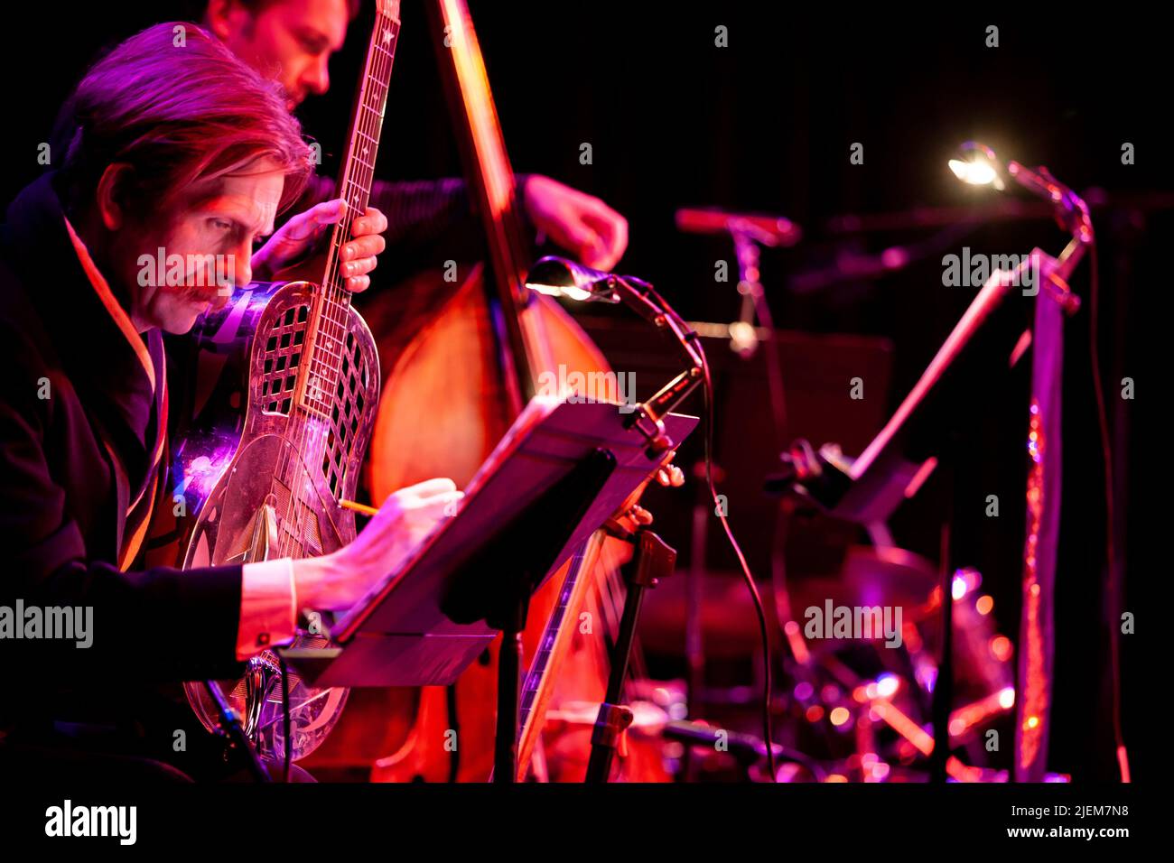 Big Band: guitar and double bass. A jazz guitarist making notes on his music. From a series of images of musicians in a swing Jazz band. Stock Photo