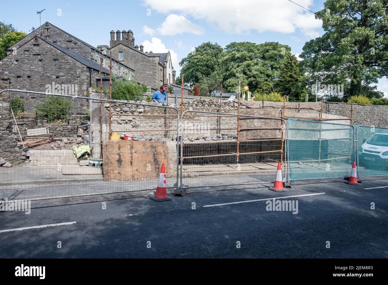 Starting to level off the 'garden' wall above  block-supported section of wall ready for top layer of coping stones.Long Preston wall repair 27/6/22. Stock Photo