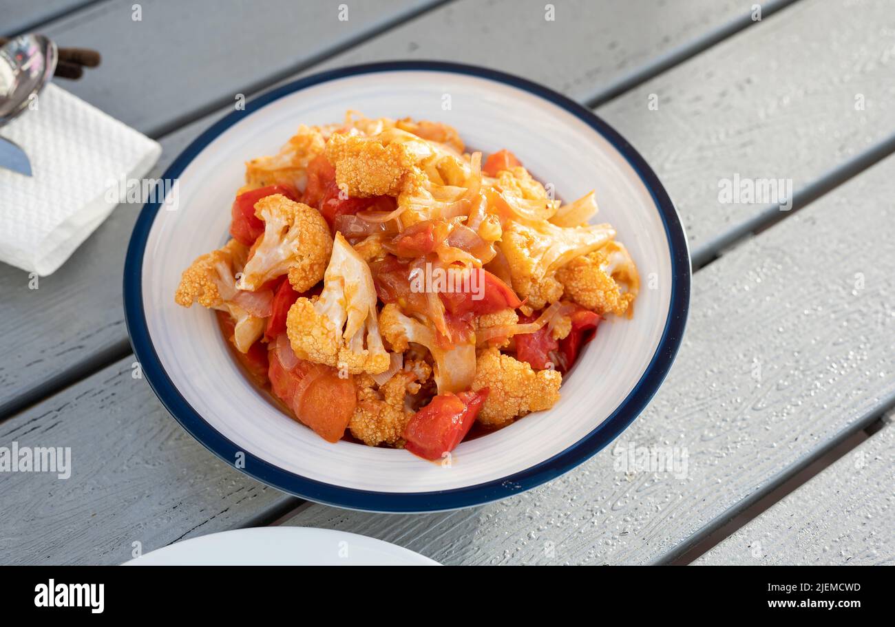 Spicy cauliflower pot with tomato and szechuan sauce on a plate top view. Chinese Asian food Stock Photo