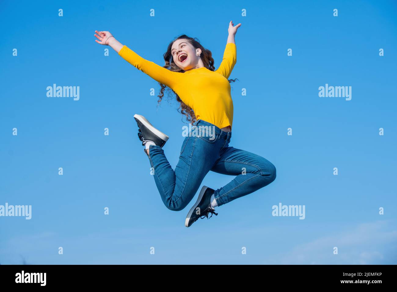 happy teen girl jumping on sky background Stock Photo - Alamy