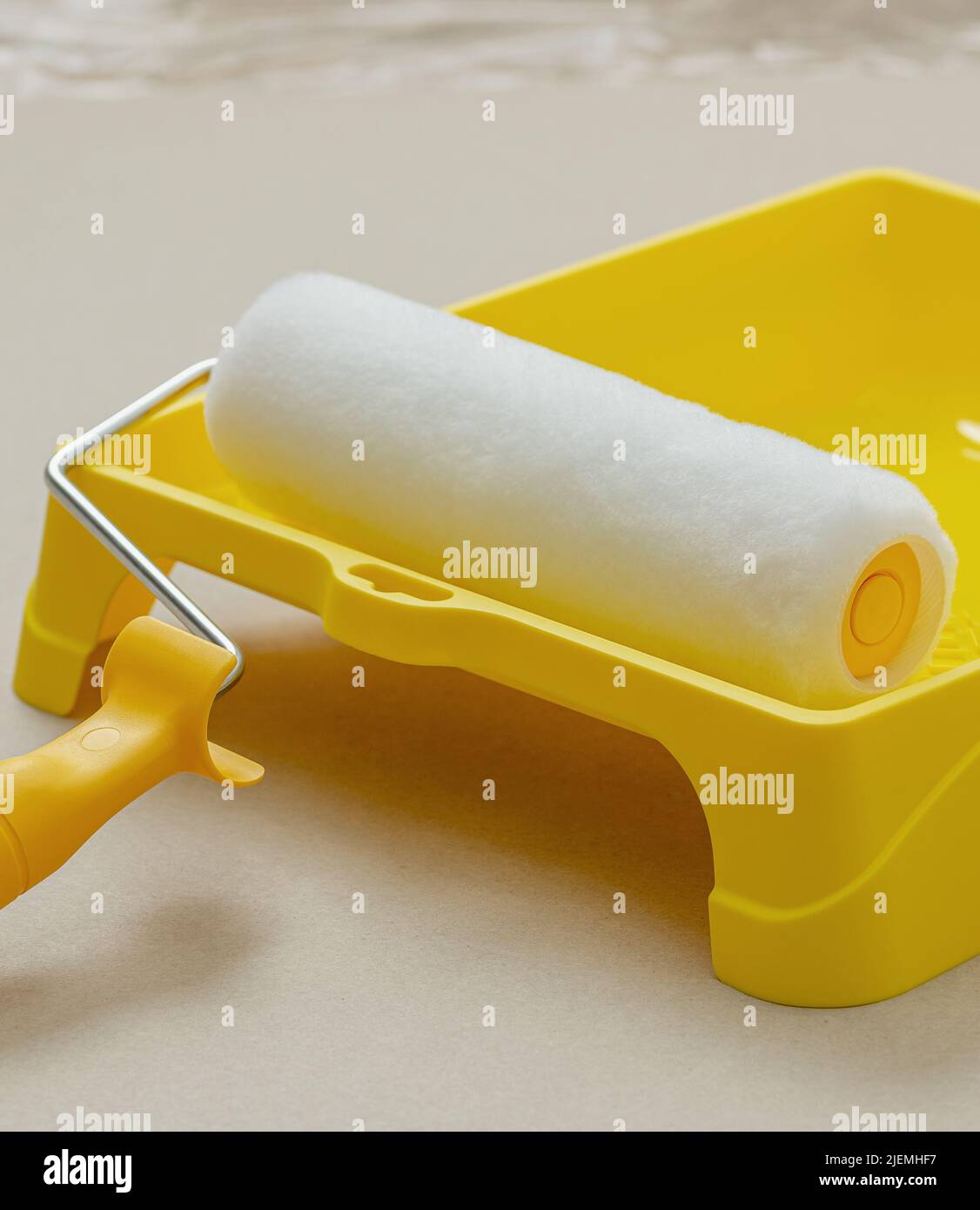 Paint roller in paint tray with white color. Repair and painting in the
