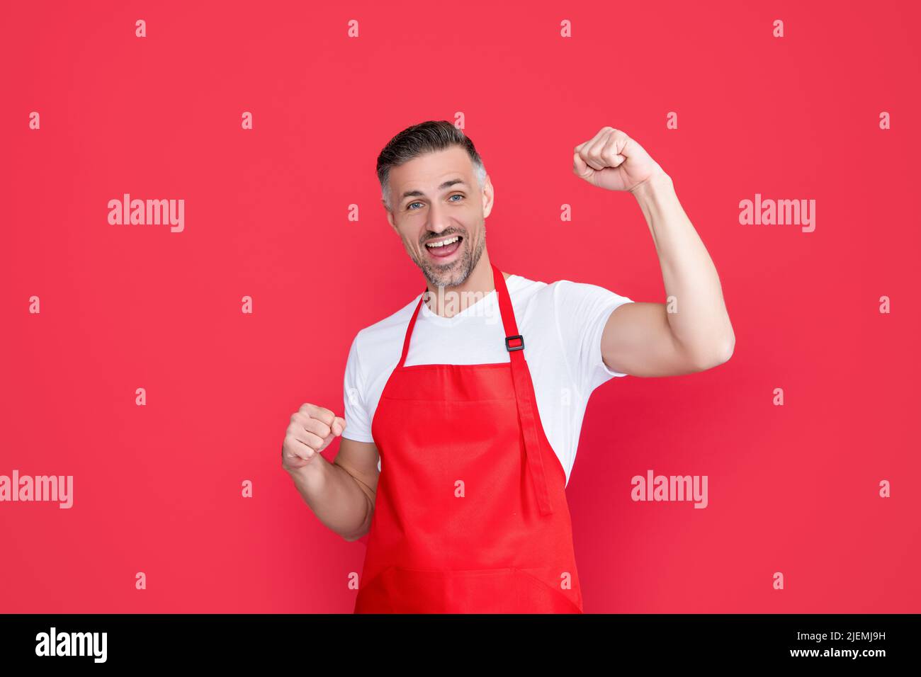 mature bartender in apron on red background Stock Photo