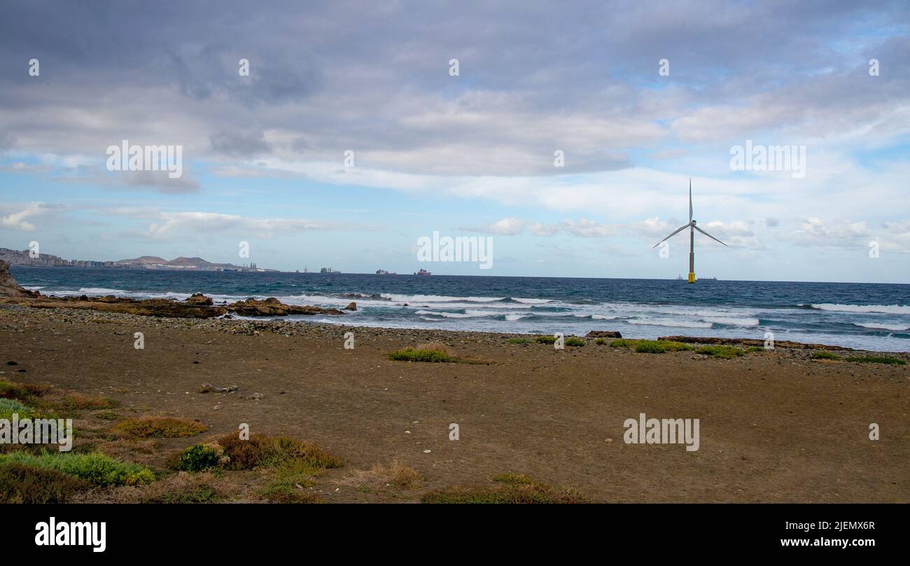 February 03 2022.A giant eolian wind turbine producing green energy in the Atlantic Ocean near the western coast of Gran Canaria.In the background are Stock Photo