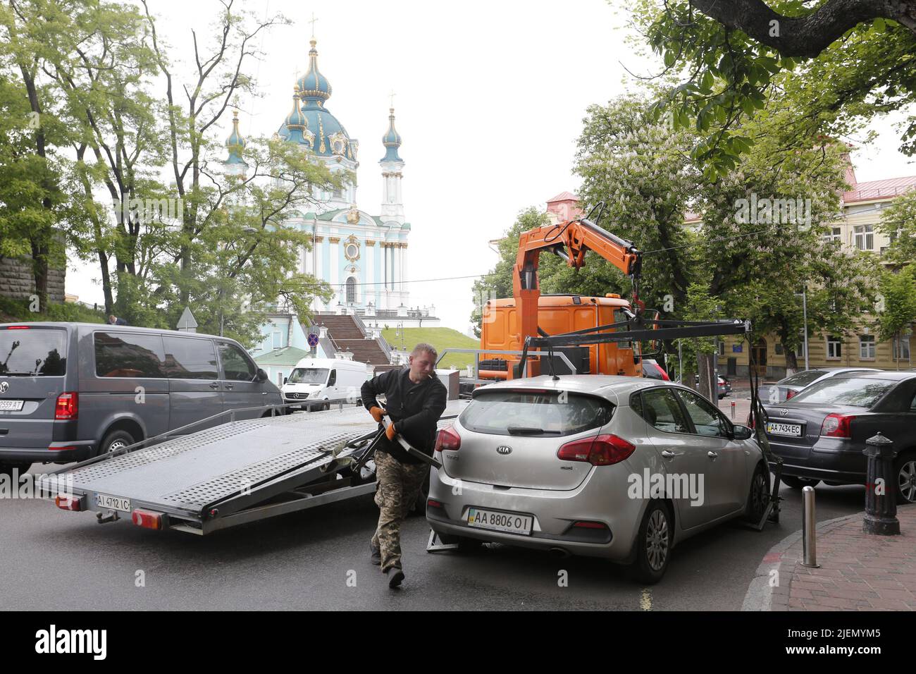 Tow truck team prepares to remove illegally parked car from the road near the legendary St Andrews church in Kiev, on the top of St Andrew Hill Stock Photo
