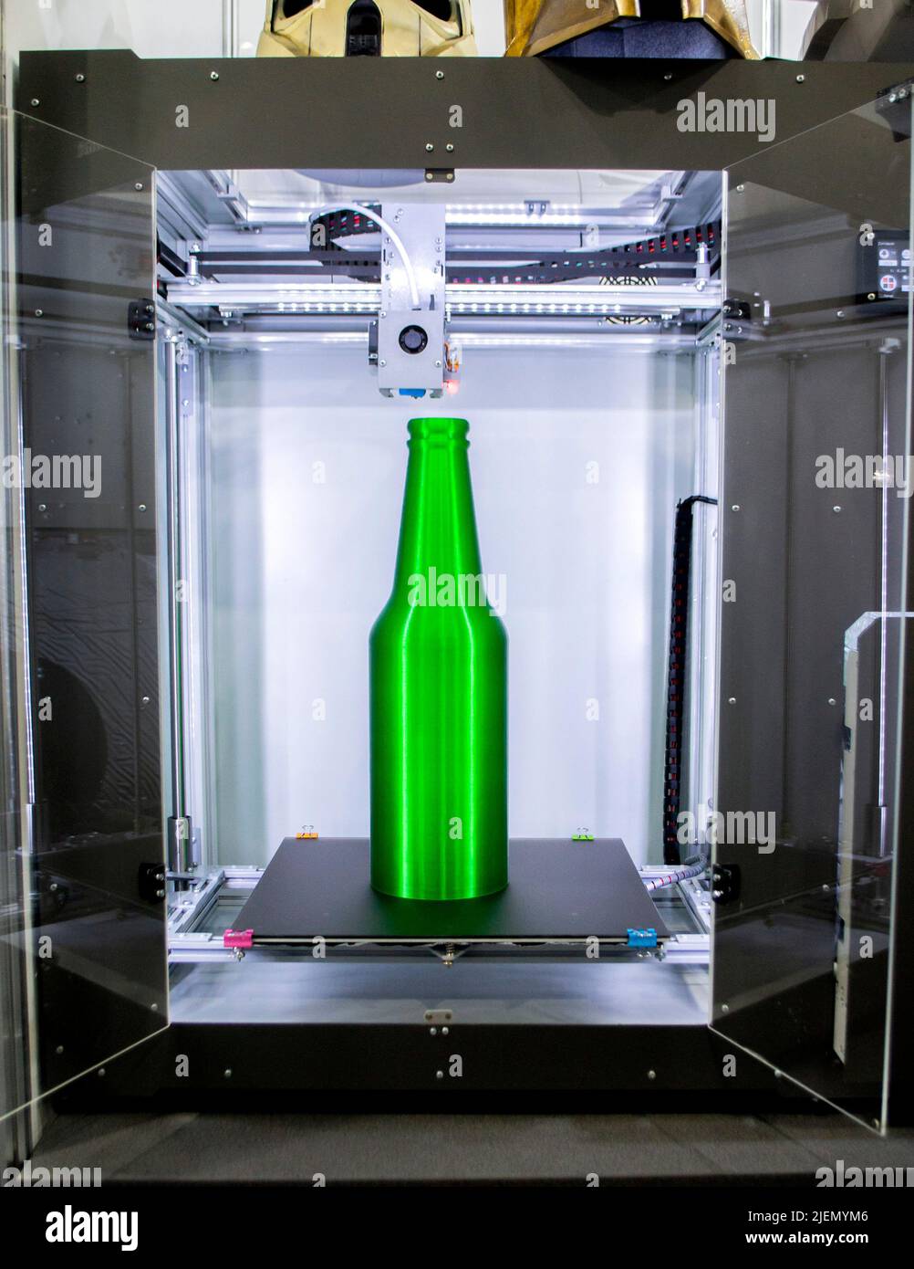Object green bottle printed on 3D printer close-up, inside on desktop ...