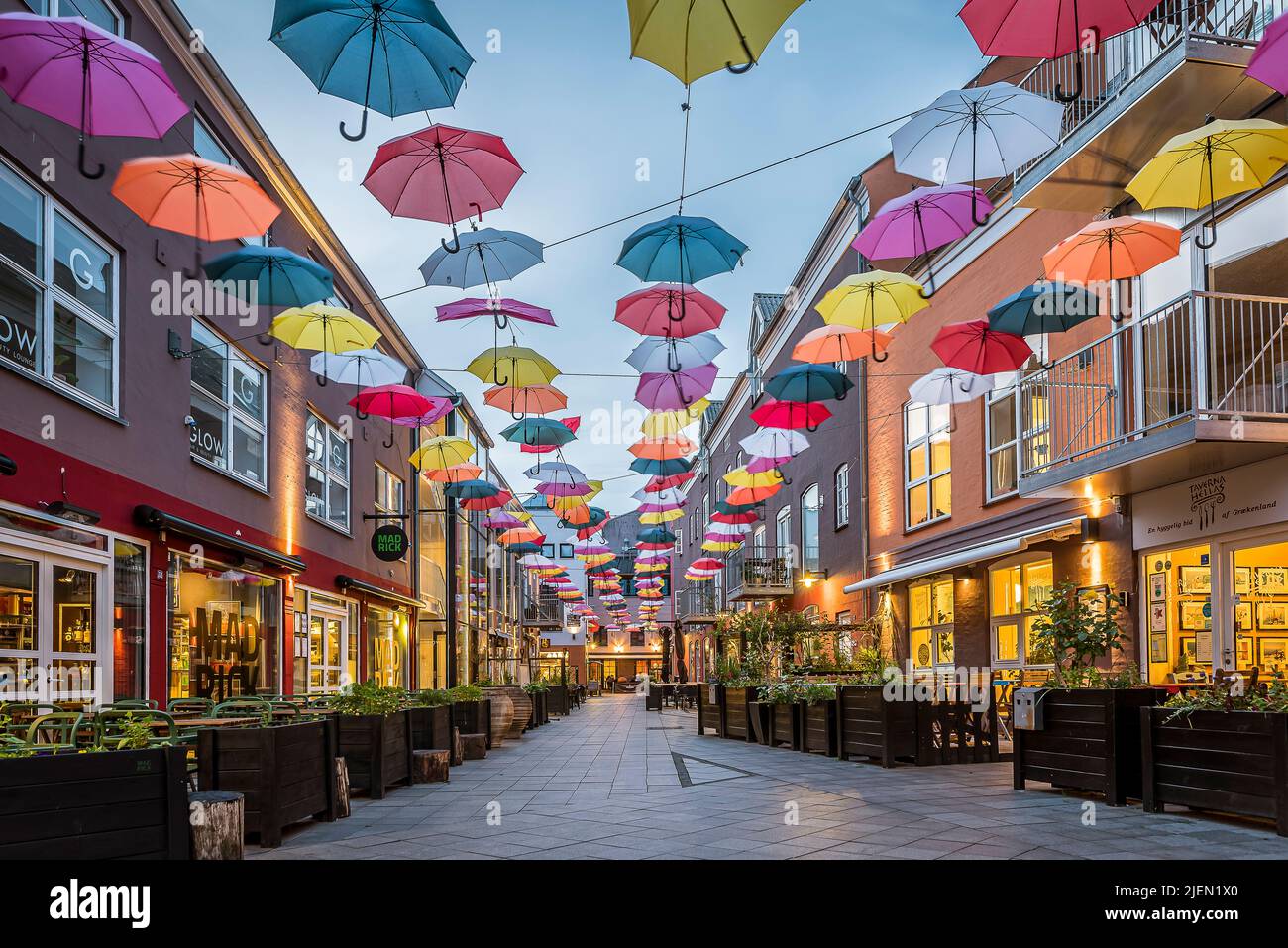colourful umbrellas in the soft evening light over a street at the Latin Quarter in Vejle, June 14, 2022 Stock Photo
