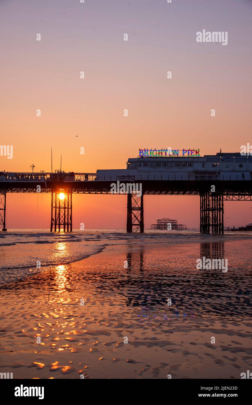Sunset at Brighton Pier during low tide. West Pier is visible through