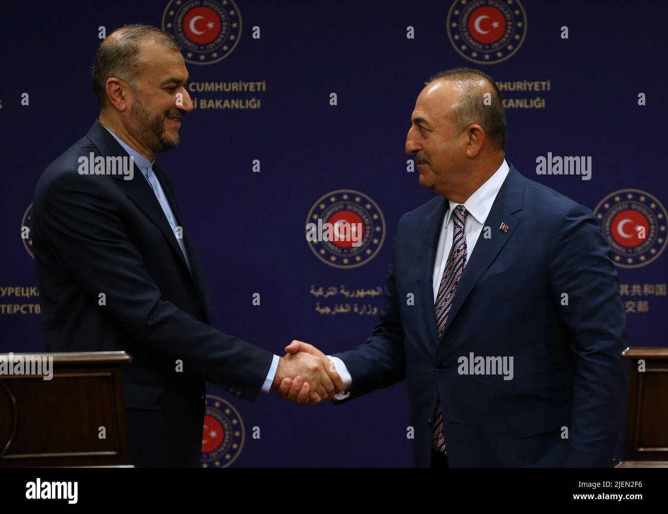 Ankara, Turkey. 27th June, 2022. Turkish Foreign Minister Mevlut Cavusoglu (R) and Iranian Foreign Minister Hossein Amir-Abdollahian shake hands at a joint press conference in Ankara, Turkey, on June 27, 2022. Turkey is against the unilateral sanctions on Iran, Turkish Foreign Minister Mevlut Cavusoglu said on Monday, voicing hopes for the nuclear deal to be restored. Credit: Mustafa Kaya/Xinhua/Alamy Live News Stock Photo