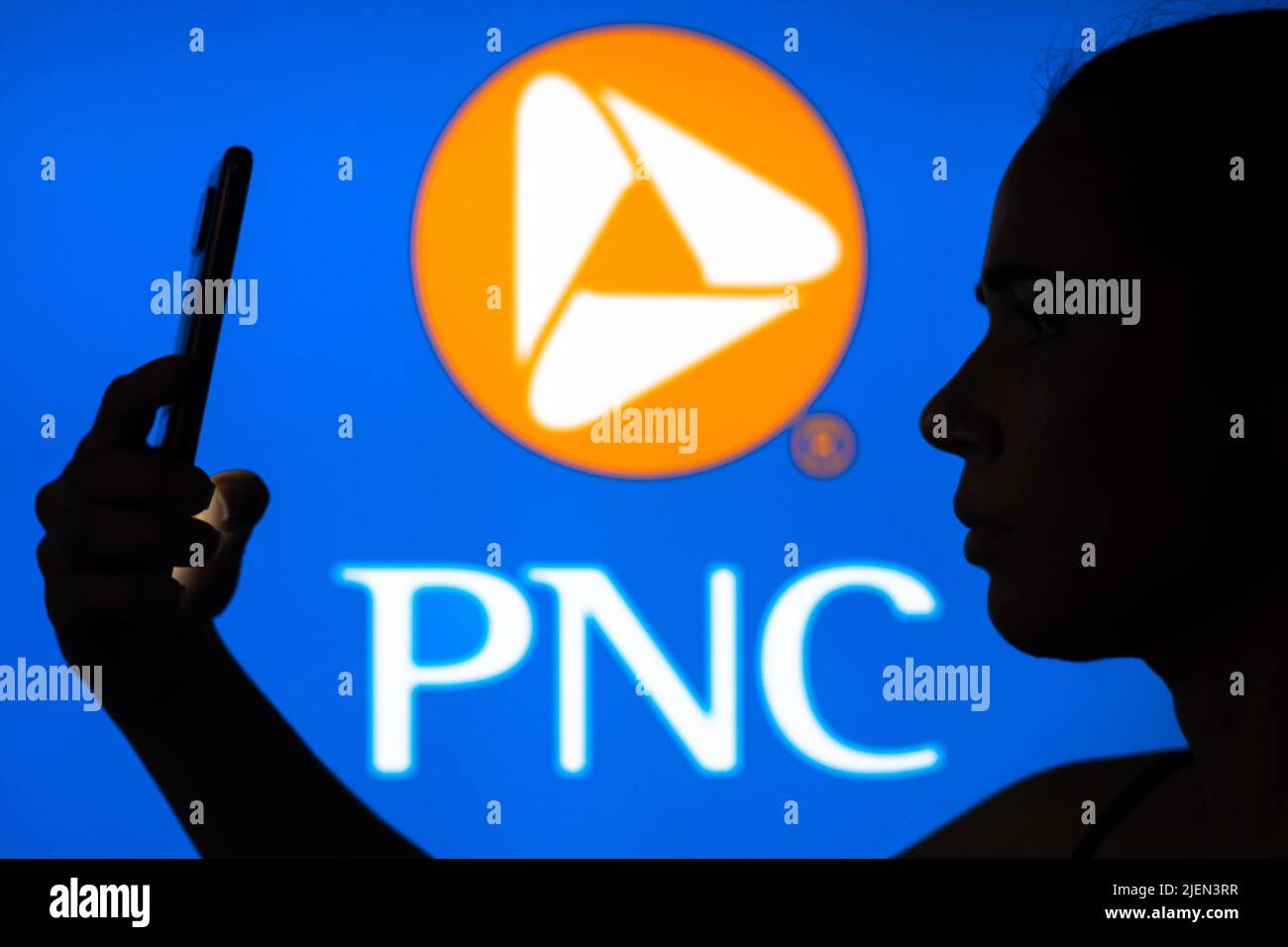 In this photo illustration, the PNC Financial Services Group logo is seen in the background of a