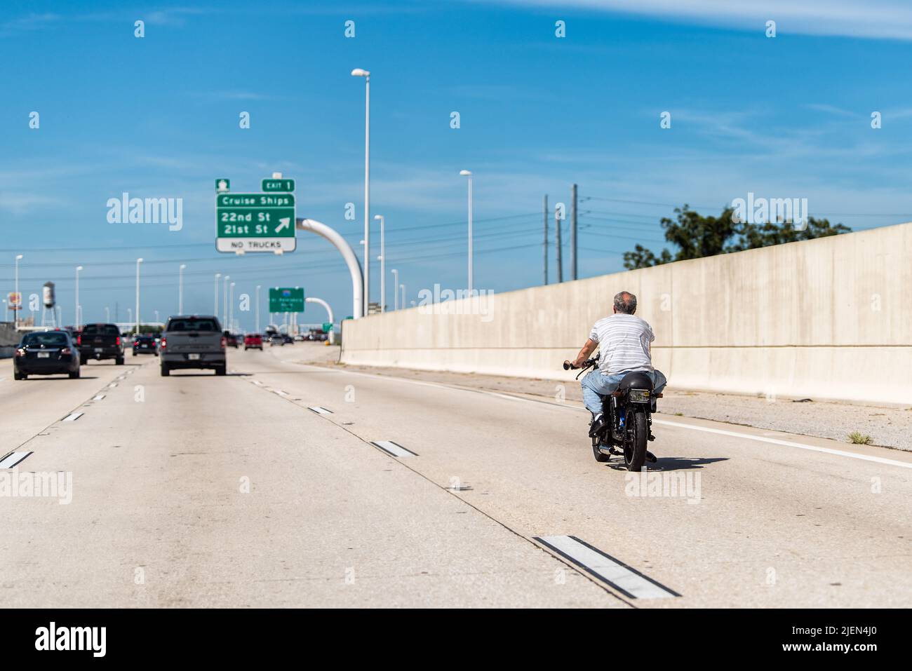 Tampa, USA - October 4, 2021: Road street interstate highway in Florida with car traffic point of view and man on motorcycle without helmet riding dan Stock Photo