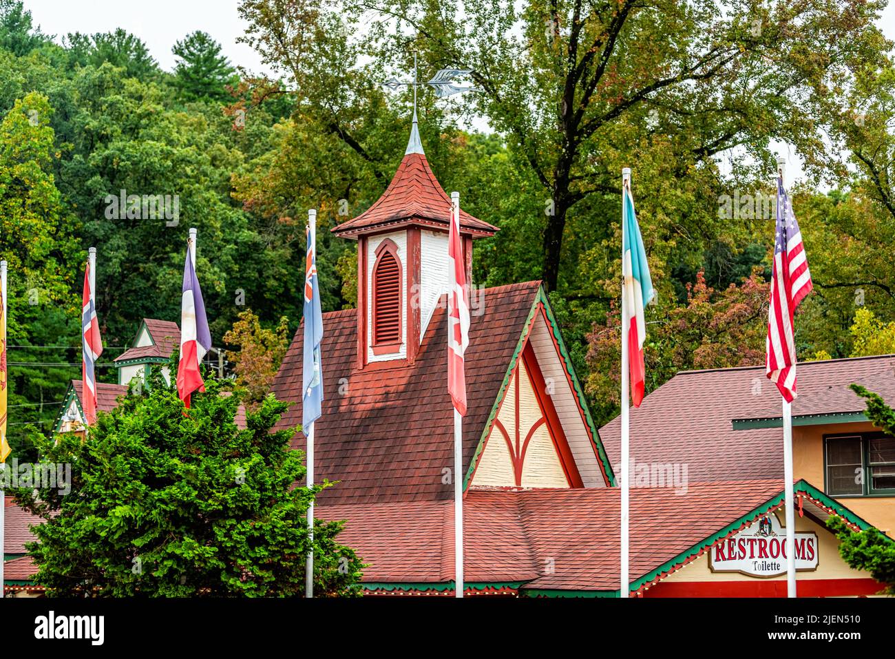 Helen, USA - October 5, 2021: Bavarian village of Helen, Georgia with house building tower on main street alpine architecture with flags and sign for Stock Photo