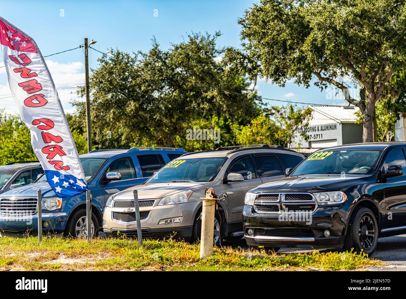 Lake Alfred, USA - October 19, 2021: Local used car auto dealer dealership with cars parked on parking lot display with price tags on windshield windo Stock Photo