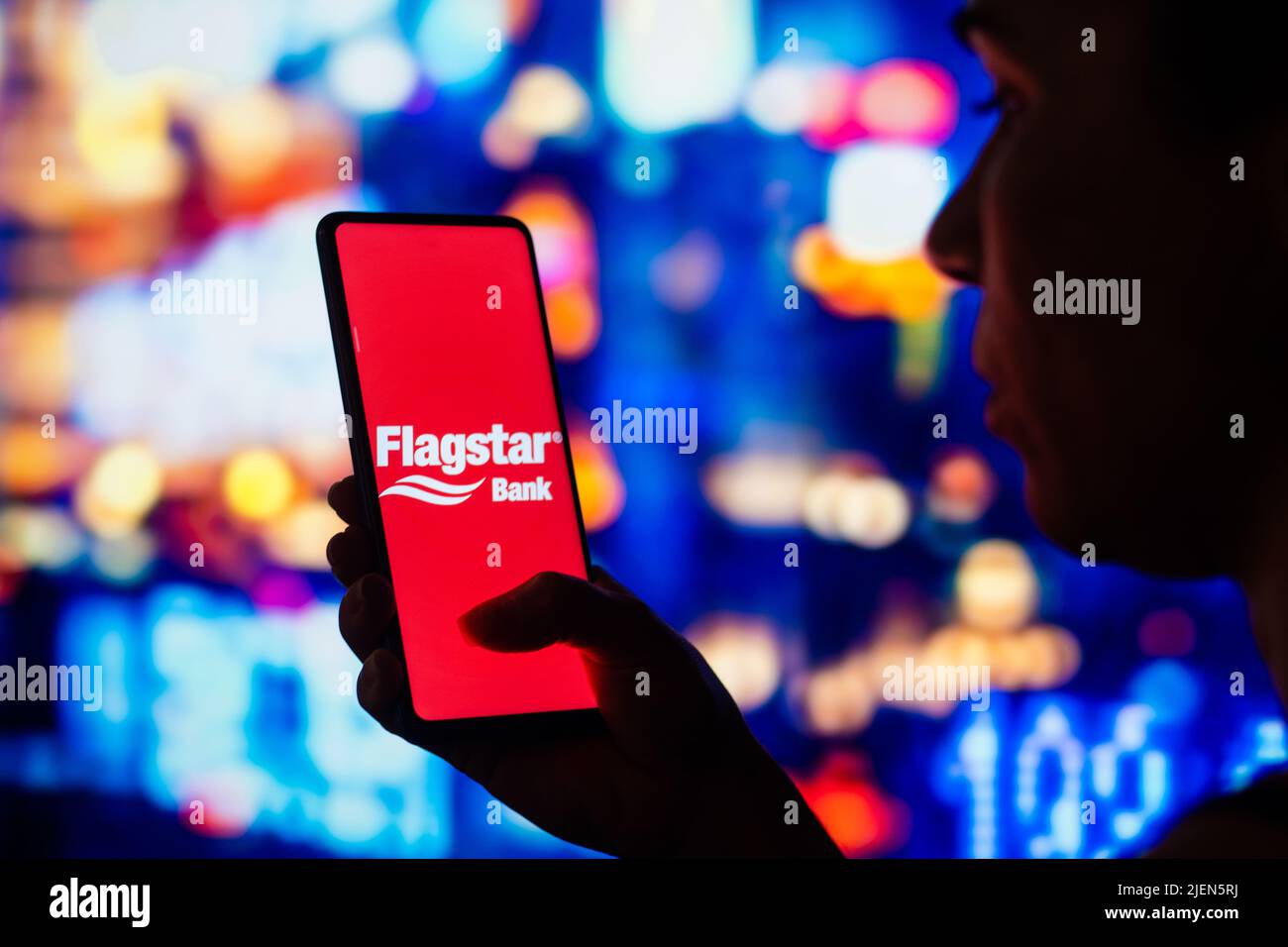 In this photo illustration, a silhouetted woman holds a smartphone with