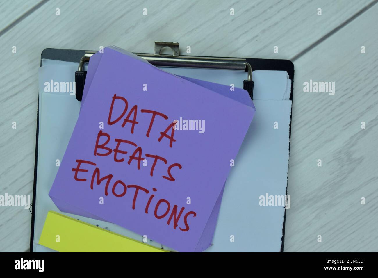 Concept of Data Beats Emotions write on sticky notes isolated on Wooden Table. Stock Photo