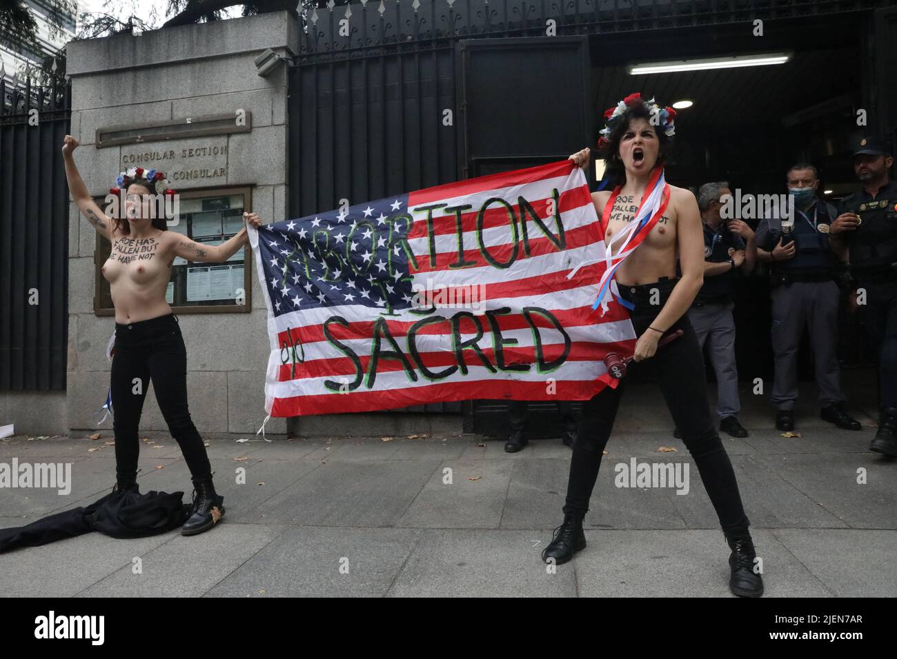 Madrid, Spain. 27th June, 2022. Members of the women's activist group Femen protest with a banner that reads 'abortion is sacred' in front of the U.S. embassy in Madrid, Spain, on June 27, 2022, following the US Supreme Court decision to end the constitutional right to abortion. Credit: Isabel Infantes/Alamy Live News Stock Photo