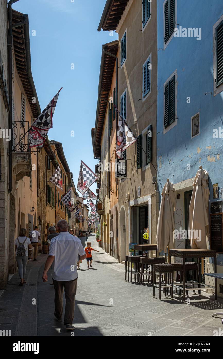Via Dante Alighieri in summer sunshine, San Quirico d'Orcia, Tuscany, Italy Stock Photo
