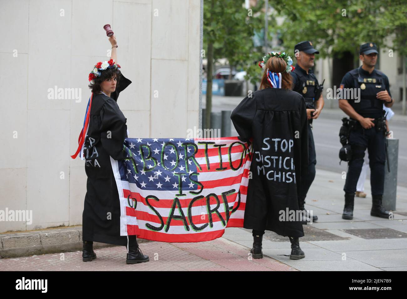 Madrid, Spain. 27th June, 2022. Members of the women's activist group Femen protest with a banner that reads 'abortion is sacred' in front of the U.S. embassy in Madrid, Spain, on June 27, 2022, following the US Supreme Court decision to end the constitutional right to abortion. Credit: Isabel Infantes/Alamy Live News Stock Photo