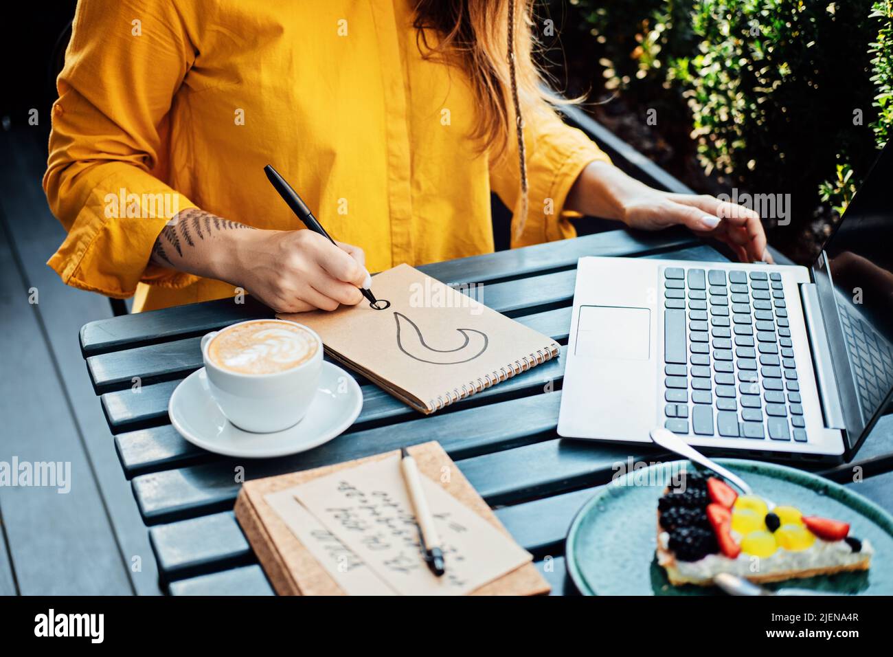 Freelancer problem challenges, Finding work, Finding clients. Freelancer woman working with laptop and writing question mark in notepad while sitting Stock Photo