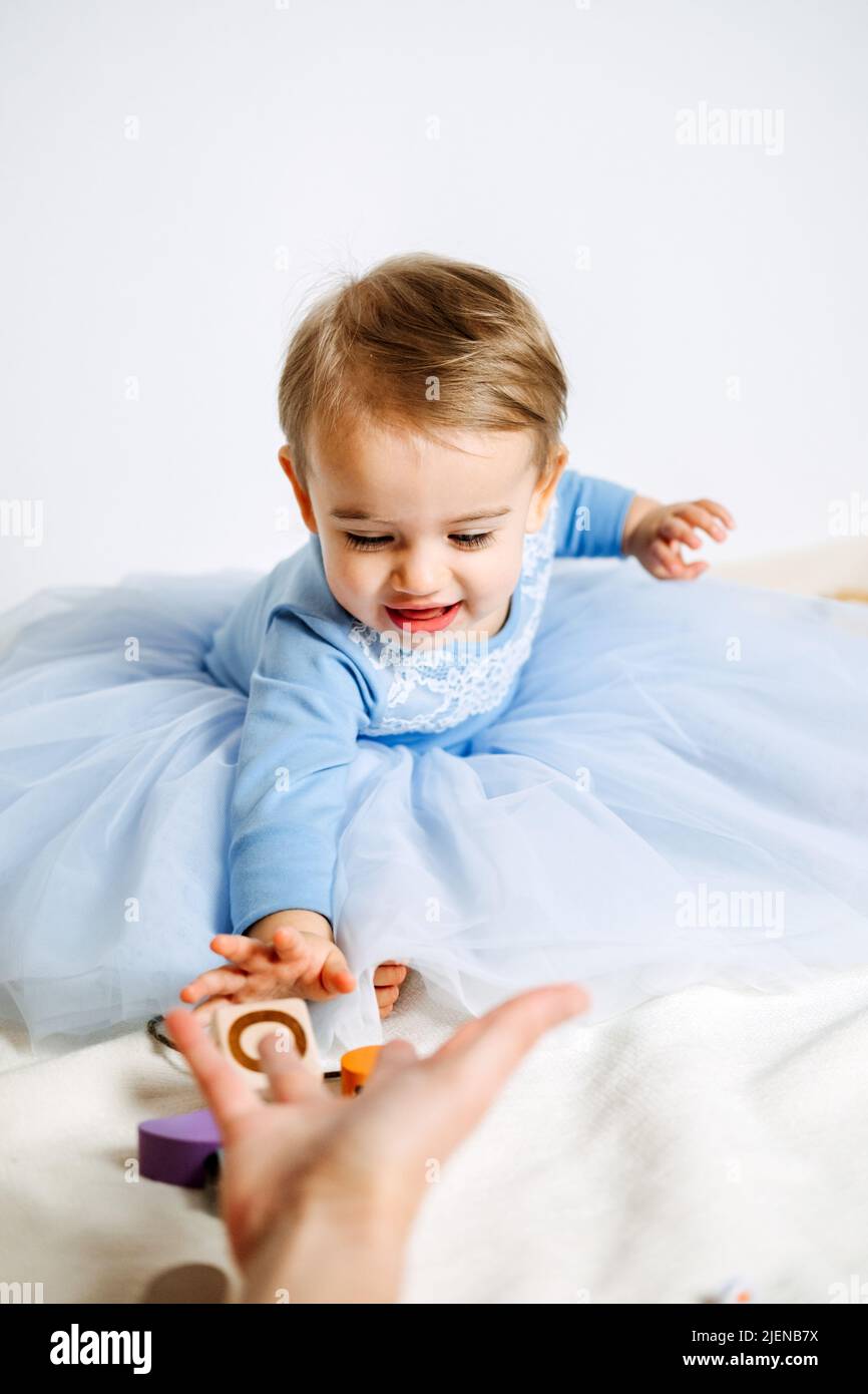 Cute baby girl in blue princess dress playing toys with mom at home. Kids dresses for birthday holiday Stock Photo Alamy