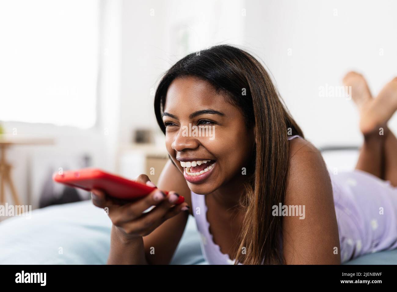 Happy teenager african american girl recording audio message on phone Stock Photo