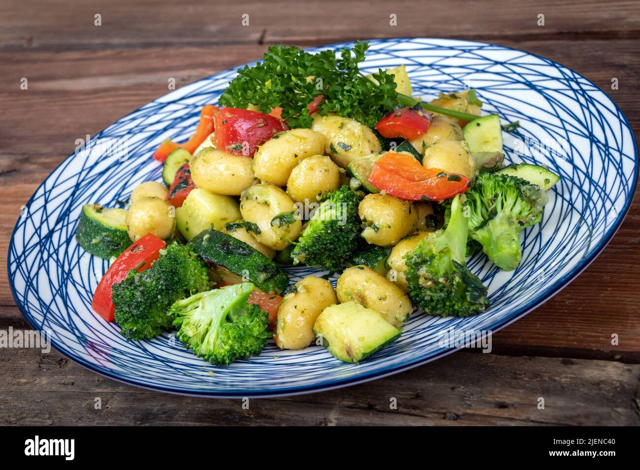 Herb and cheese gnocci pasta with veggies dish on table Stock Photo