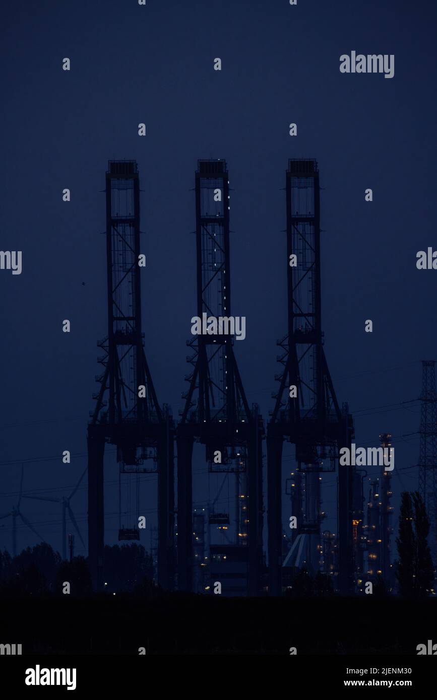 Antwerp, Belgium, Europe, 20th of april, 2022, A row of container cranes jut out into Antwerp Harbor on a foggy evening. High quality photo Stock Photo