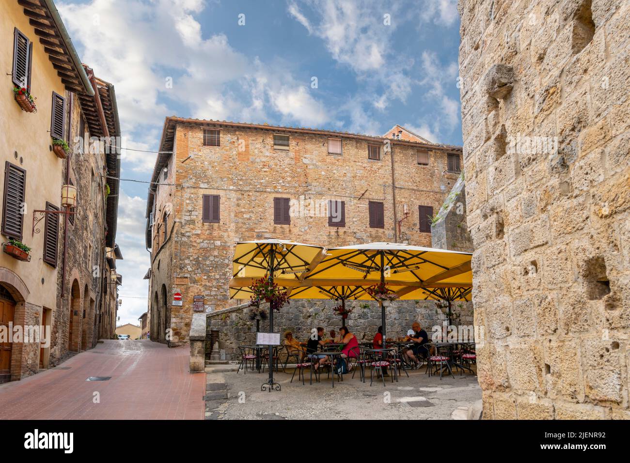 A small outdoor sidewalk cafe inside the walls of the medieval hill town of San Gimignano, Italy, in the Tuscany region. Stock Photo