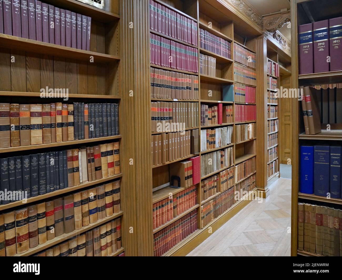 Library with wooden book shelves and bound sets of old legal texts Stock Photo