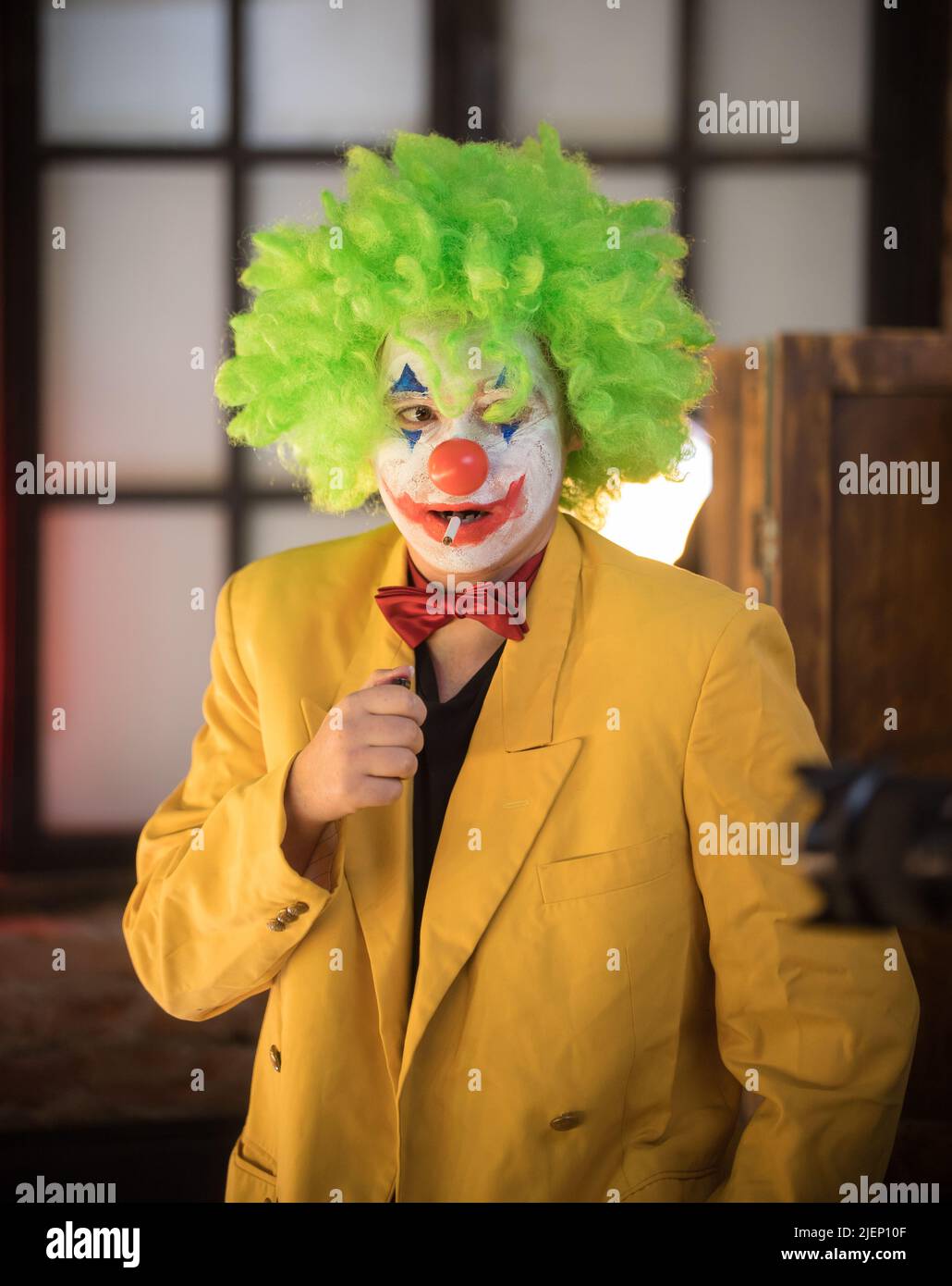 Clown concept - a lost man clown in yellow jacket and green wig with a ...