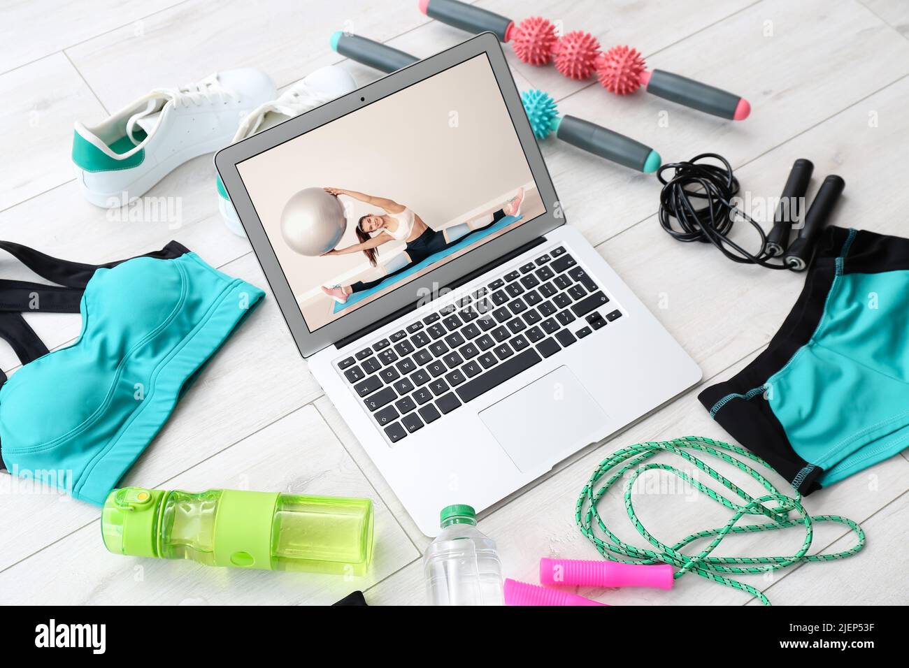 Different sport equipment and laptop on floor. Concept of online