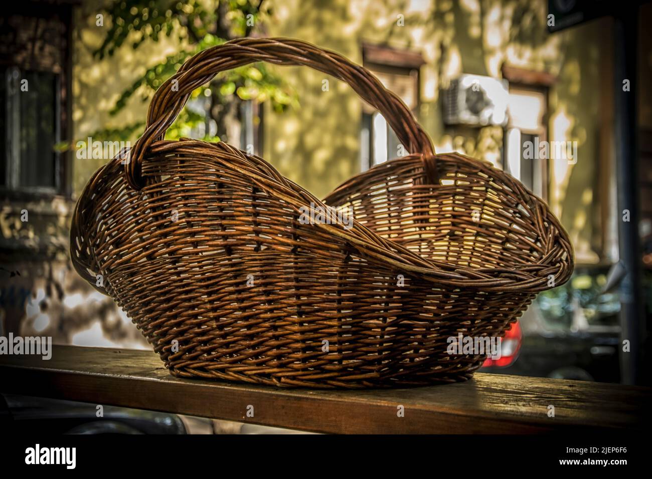 A Big Wicker Basket on a table outdoors Stock Photo