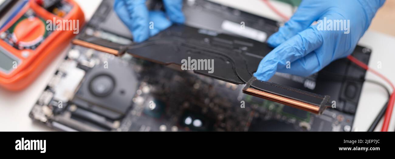 Gloved hands hold a laptop microcircuit, close-up Stock Photo