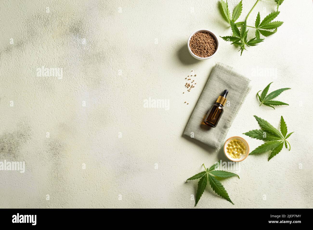 Hemp oil, leaves and seeds, cbd oil in bottle and capsules, alternative medicine and organic skin care concept. Copy space. Stock Photo