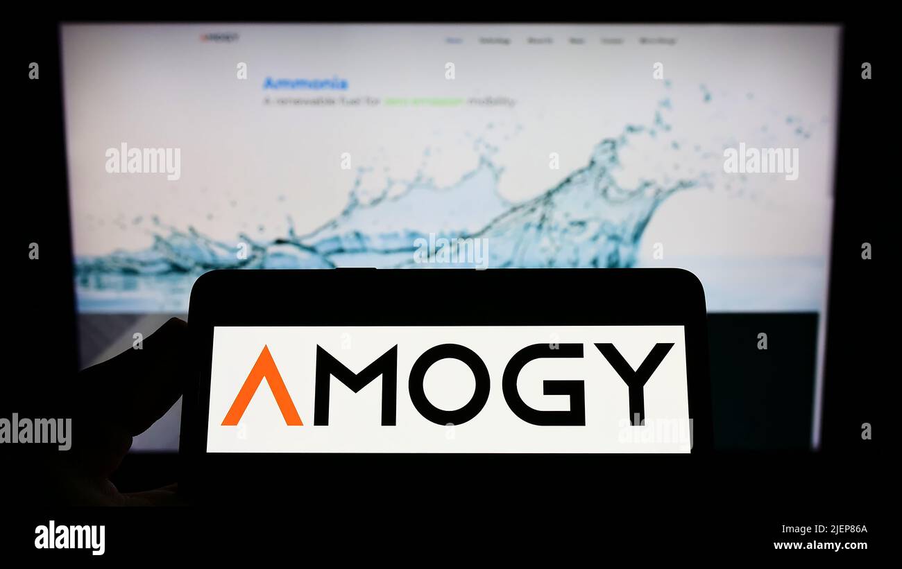 Person holding smartphone with logo of US ammonia fuel company Amogy Inc. on screen in front of website. Focus on phone display. Stock Photo