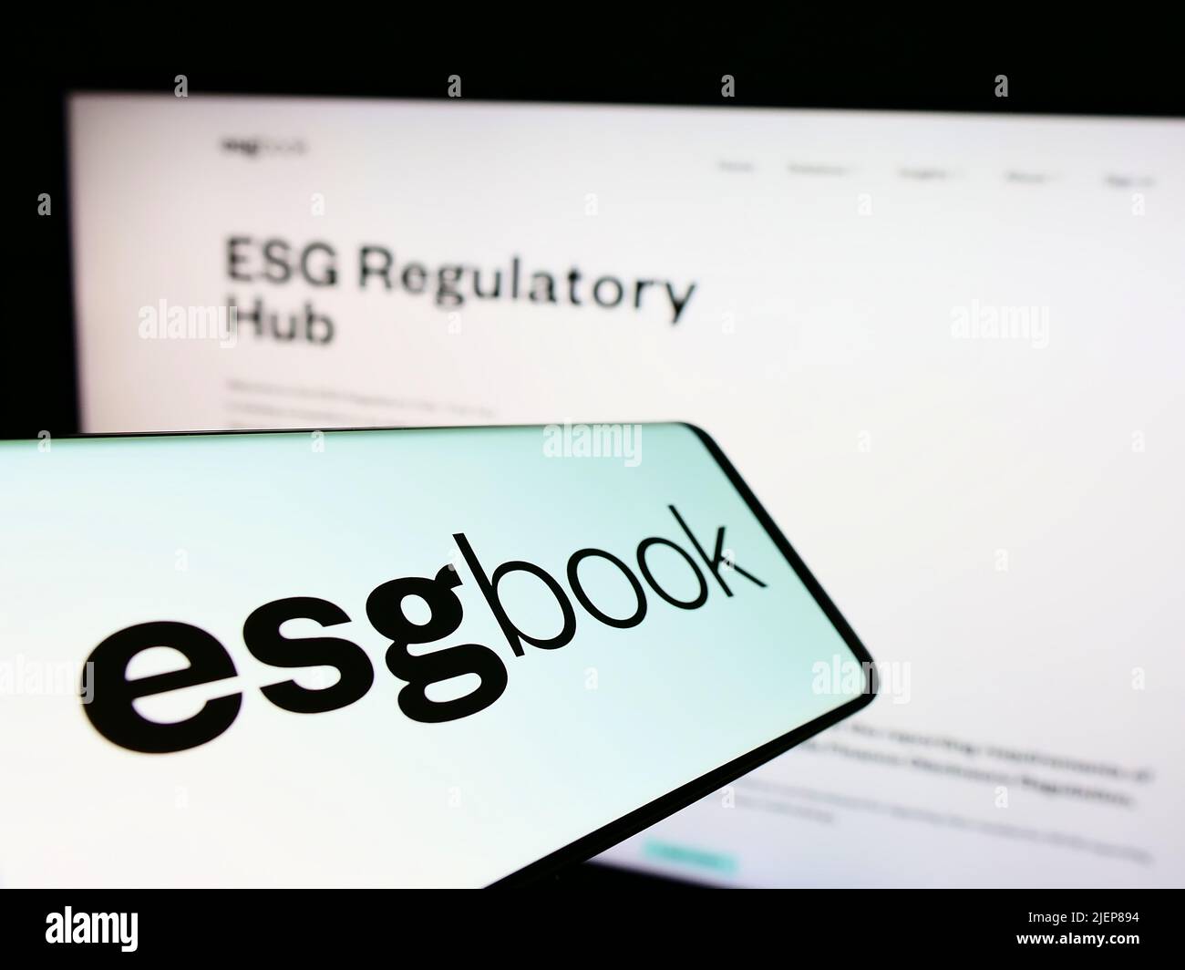 Mobile phone with logo of British sustainability data company ESG Book on screen in front of business website. Focus on center of phone display. Stock Photo