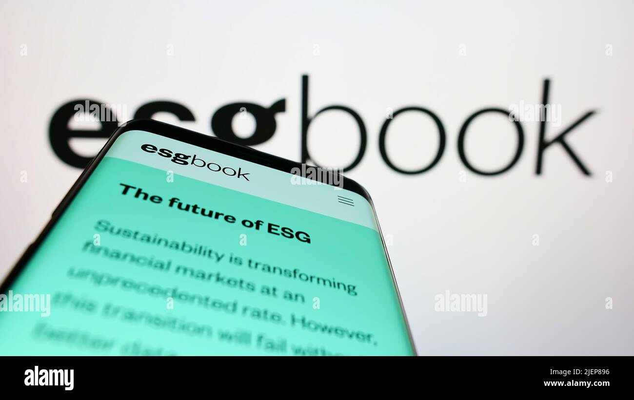 Smartphone with website of British sustainability data company ESG Book on screen in front of business logo. Focus on top-left of phone display. Stock Photo