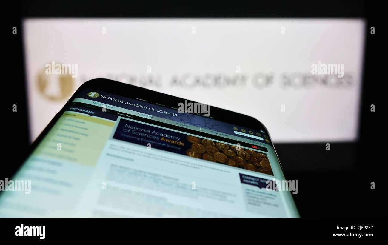 Smartphone with website of National Academy of Sciences (NAS) on screen in front of logo. Focus on top-left of phone display. Stock Photo